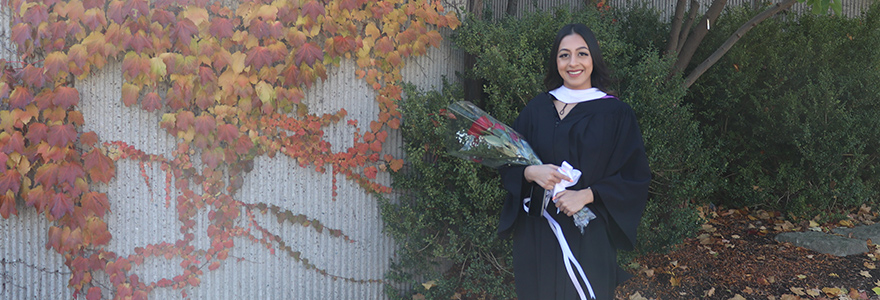 Graduate smiling with bouquet