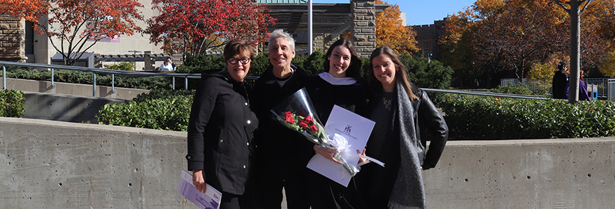 Graduate smiling with bouquet